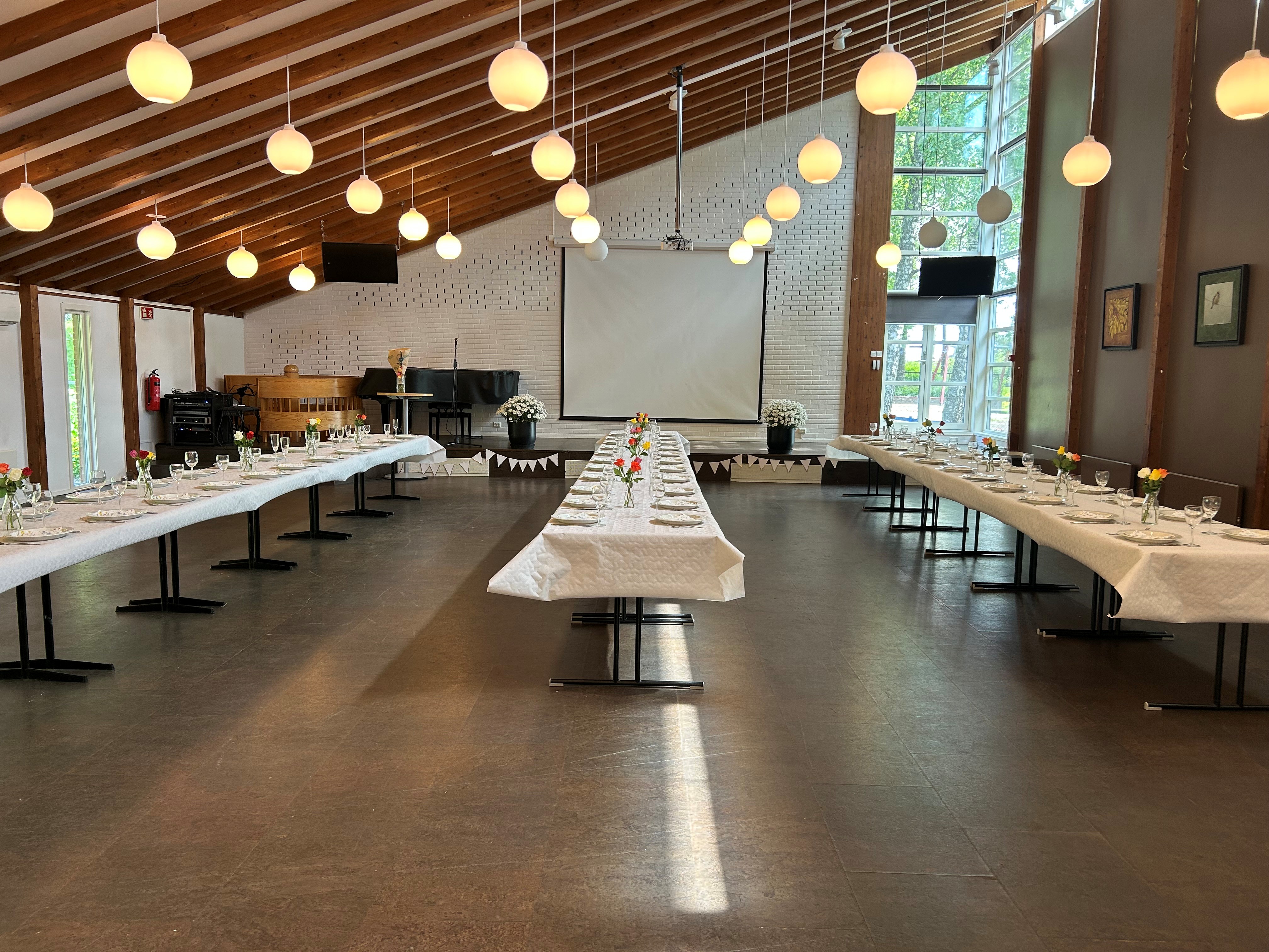 Bilde av storsalen med  dekkede bord. 