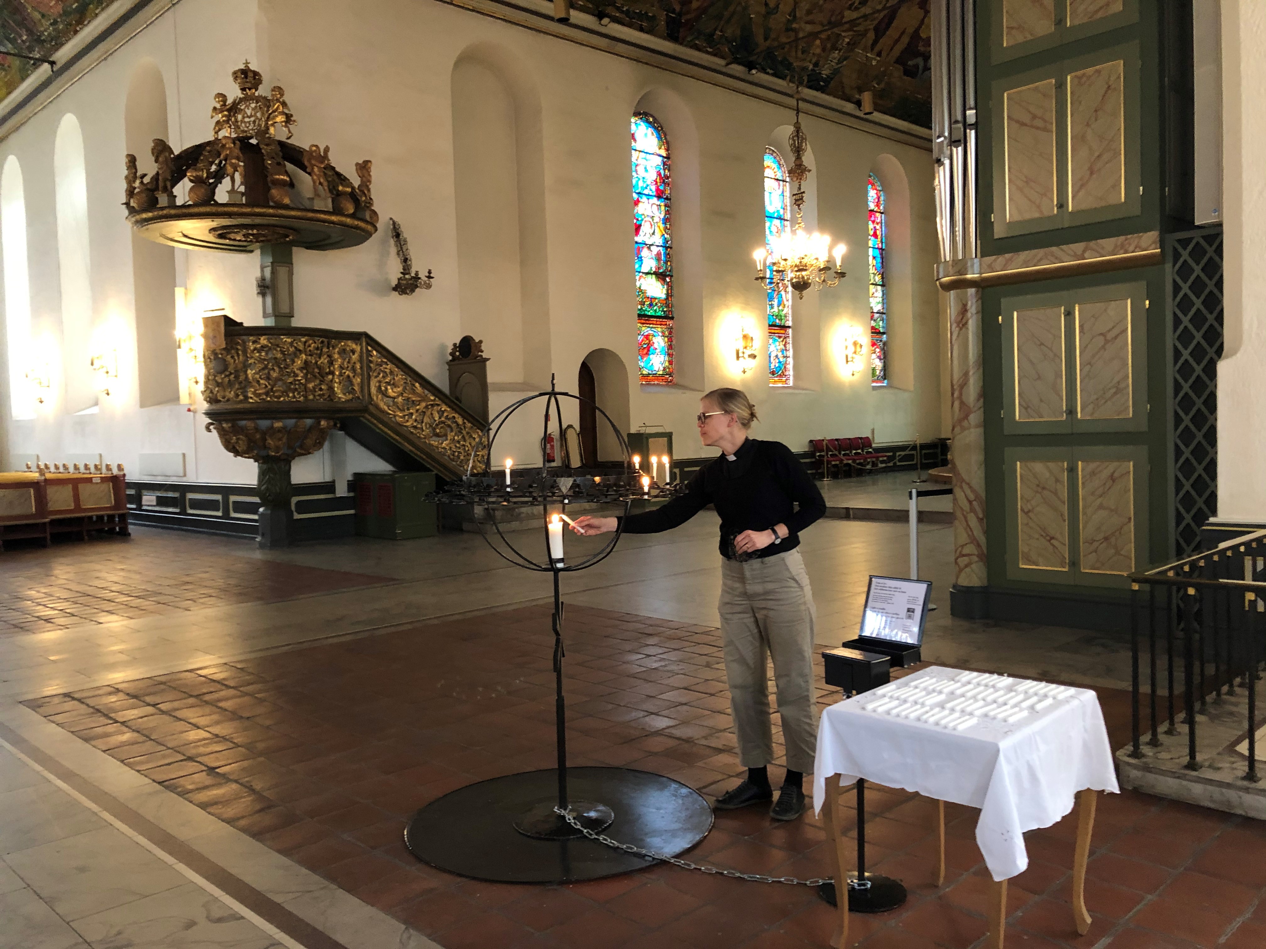 Vikarprest Åste Dokka tenner lys i globen ved middagsbønnen kl 12.00