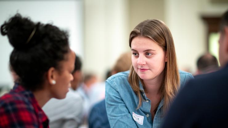 To damer sitter mot hverandre og hun ene smiler lett.