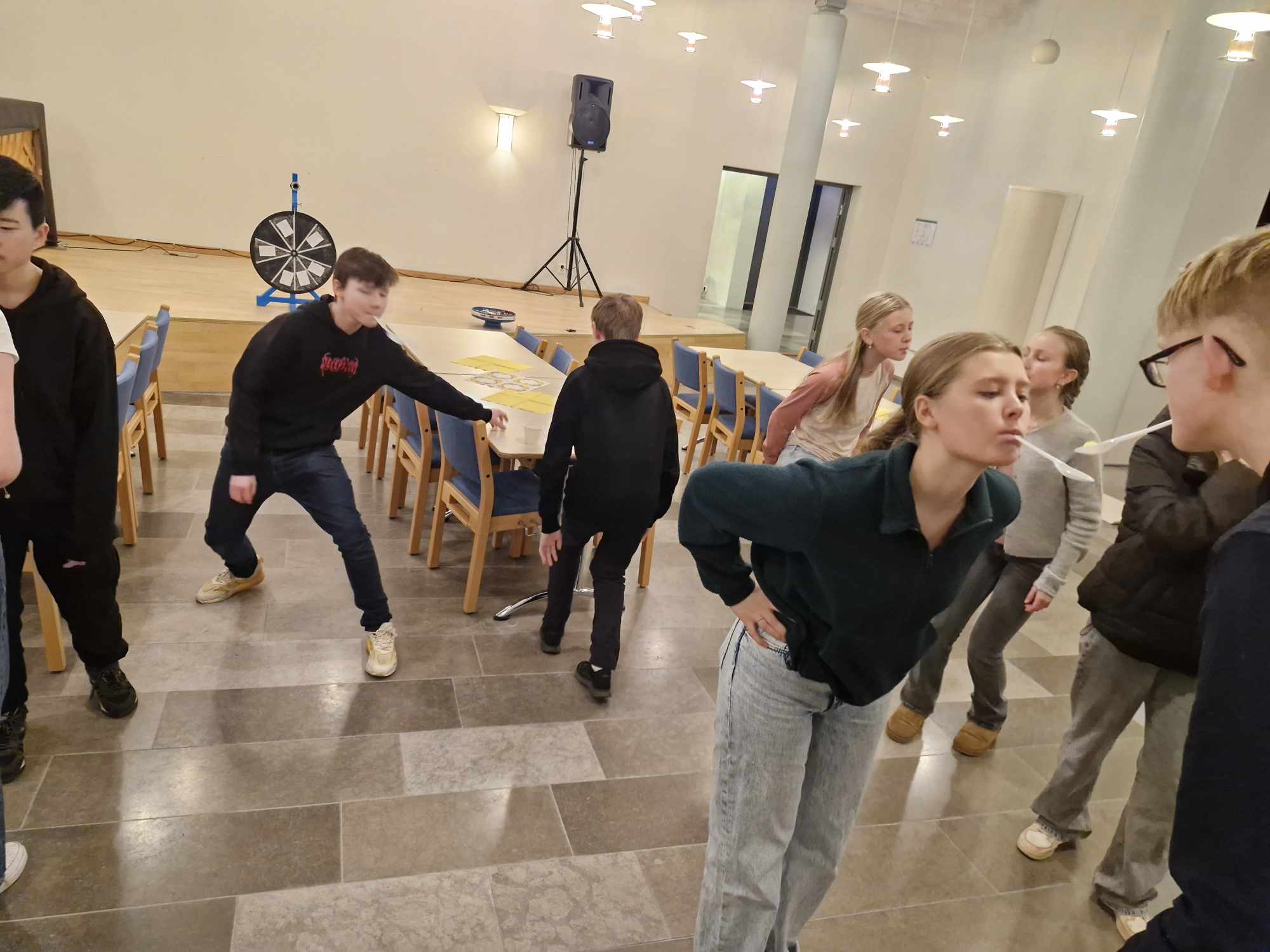 ungdommane er med i en konkurranse/leik. Dei står to og to med plastskjei i munnen