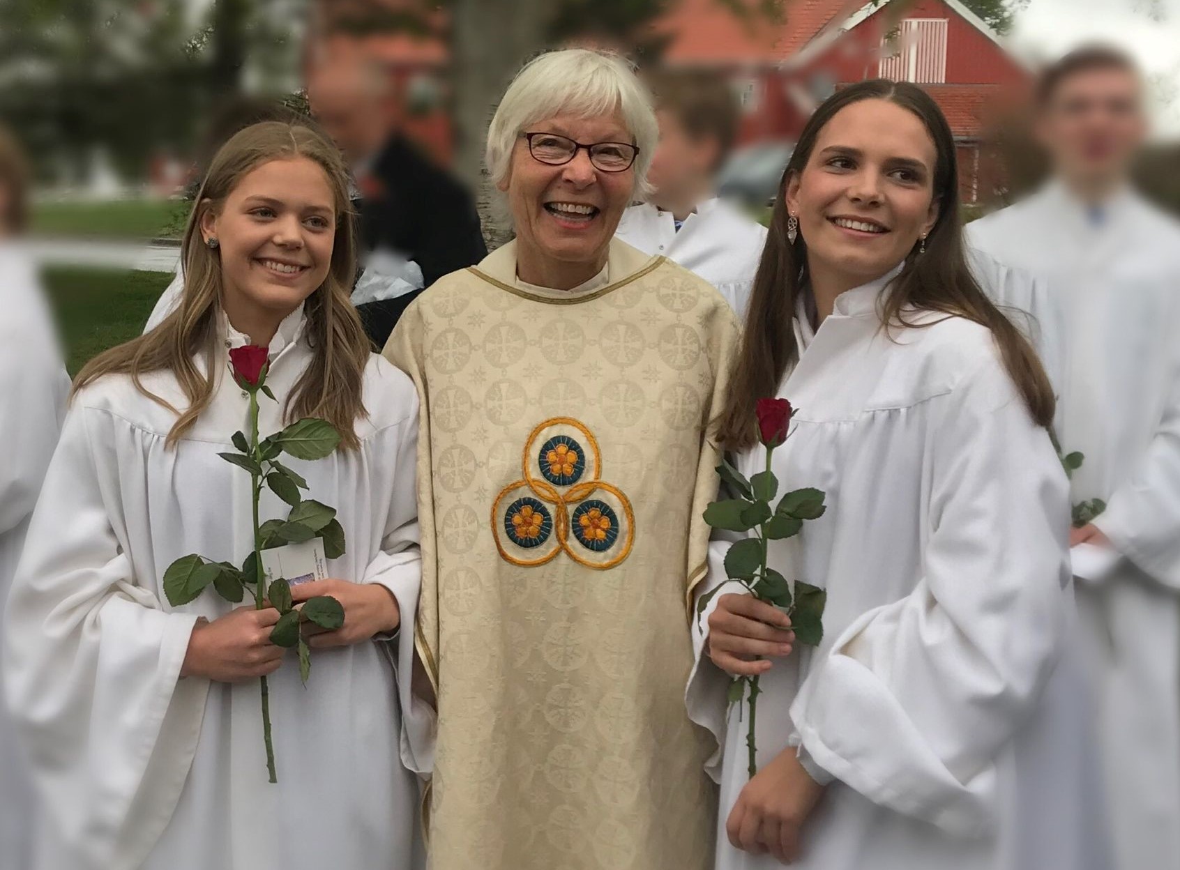 Prest Bella Svanhom samme ned to konfirmanter utenfor Berg kirke i Trondheim