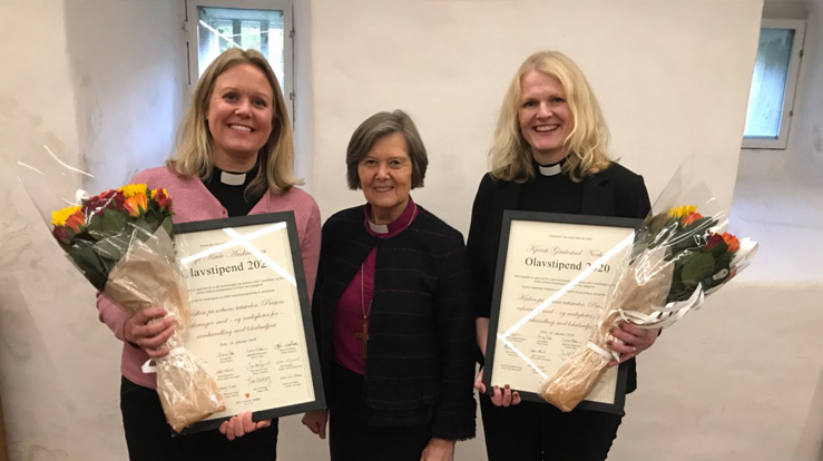 Silje Kivle Andreassen (til venstre) og Kjersti Gautestad Norheim fikk stipend og blomster overrakt av preses Helga Haugland Byfuglien. (Foto: Bispemøtet)