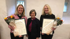 Silje Kivle Andreassen (til venstre) og Kjersti Gautestad Norheim fikk stipend og blomster overrakt av preses Helga Haugland Byfuglien. (Foto: Bispemøtet)