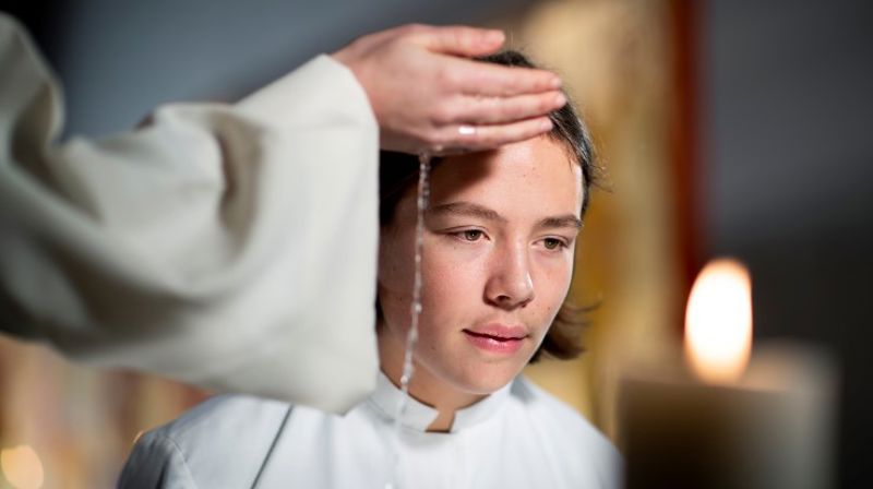 Konfirmant blir døpt.