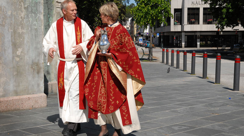 Fra omslaget til boka "Liturgiske klær". Prester i prosesjon på vei inn i Kristiansand domkirke. (Foto: Sidsel Jørgensen)